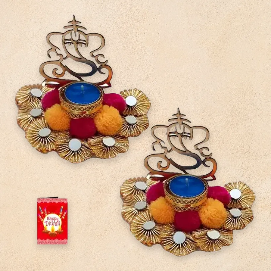 Projecting Ganesh Light Diya Set with vibrant pom-poms, sparkling mirrors, and intricate zardosi detailing, glowing warmly in a festive setting