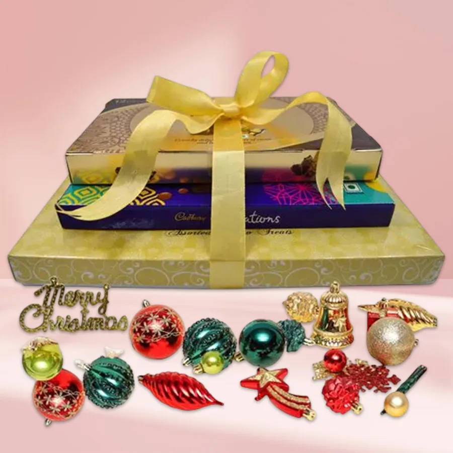 A beautifully arranged chocolate tower featuring Luxure Truffle Chocolate Box, Ferrero Rocher Moments assortment, and Cadbury Celebration Assorted Chocolates, accompanied by festive Christmas decorations.