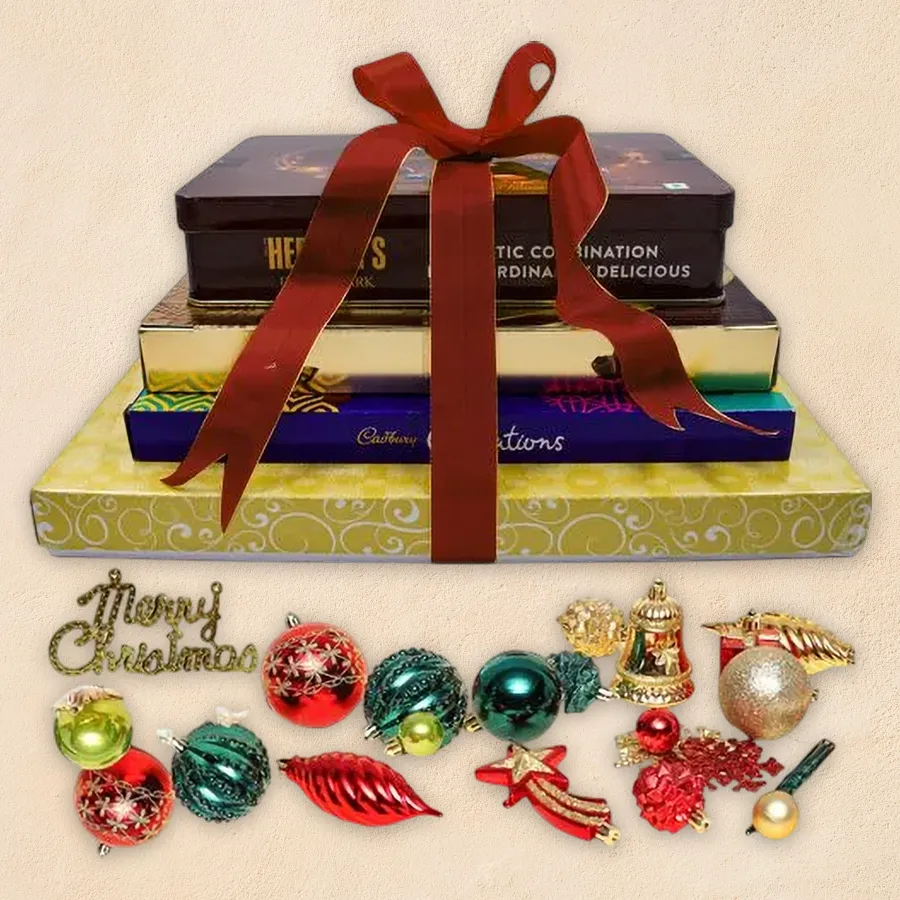 Relishing Chocolate Tower and Christmas Decor Indulgence Combo featuring Ferrero Rocher, Hershey's Kisses, Cadbury Celebration, Luxure Truffle Chocolates, and festive decorations