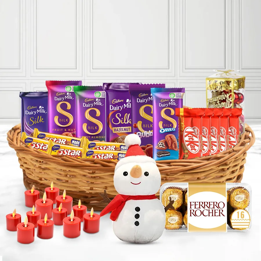 Gift basket filled with assorted chocolates, including Cadbury, Nestle, and Ferrero Rocher, decorated with Christmas ornaments, a snowman, and glowing candles.