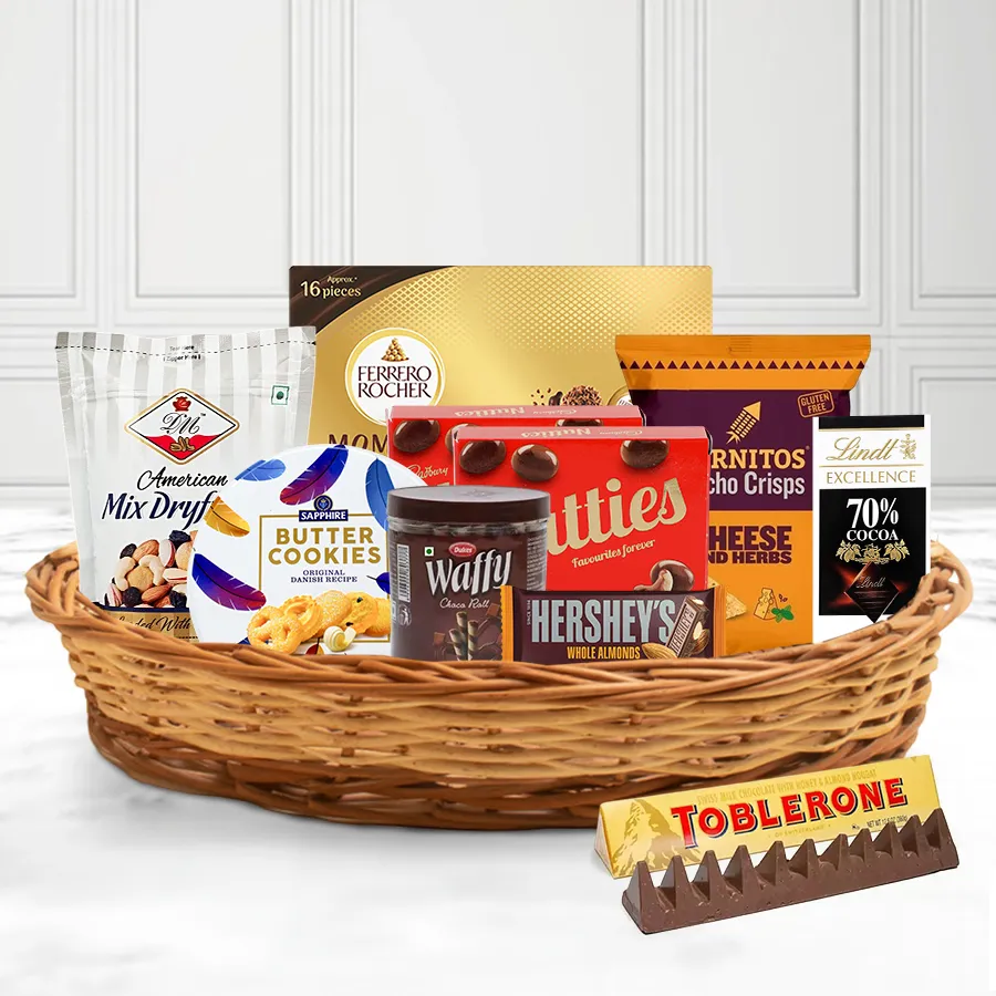 Classy Corporate Treat X-Mas Basket filled with DM Mixed Nuts, Sapphire Cookies, Dukes Wafers, Hershey’s and Toblerone chocolates, Nutties, Cornitos, Ferrero Moments, and a Lindt Excellence Dark Chocolate Bar, beautifully arranged in a reusable gift basket.