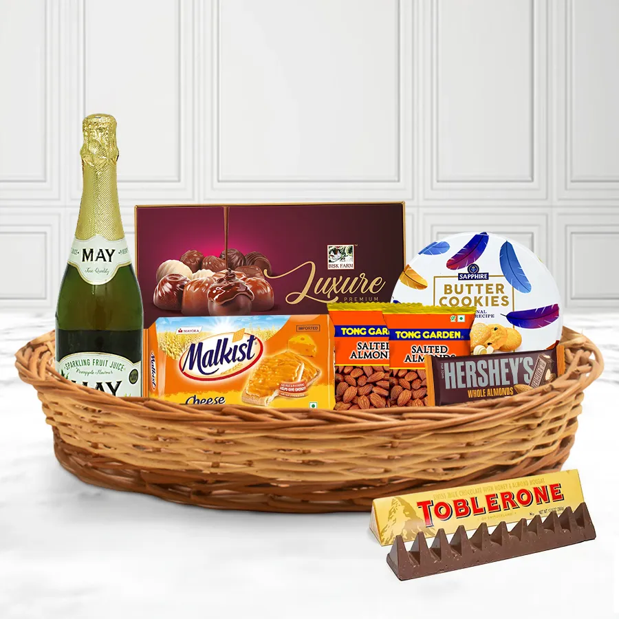Gift basket filled with festive snacks including chocolates, juice, cookies, almonds, and crackers, elegantly arranged for Christmas celebrations.