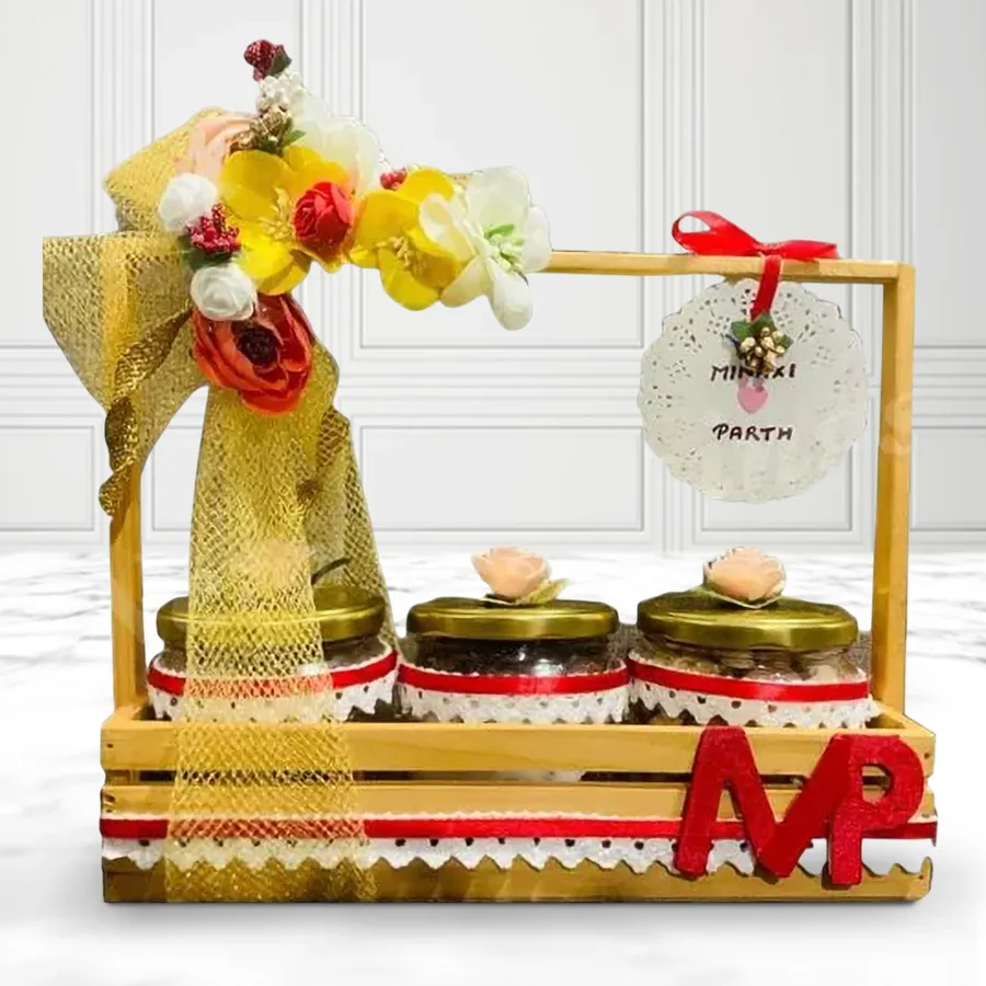 Elegant glass jar filled with assorted dry fruits, presented in a designer wooden holder tray for a wedding anniversary gift.