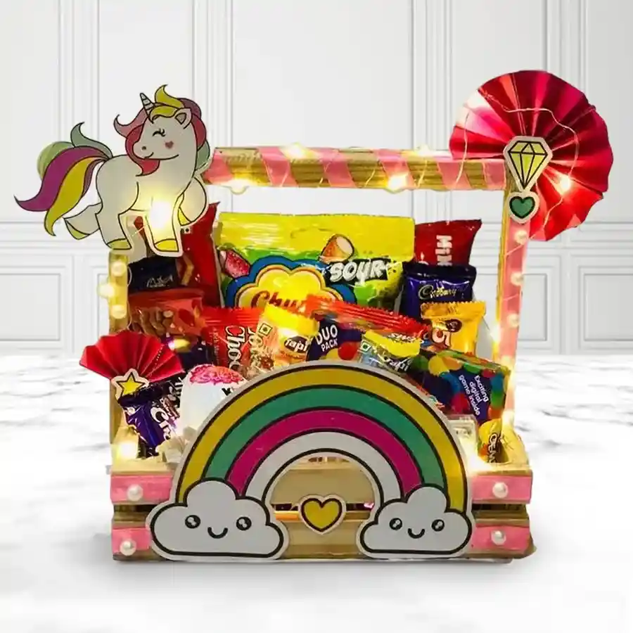 Brightly arranged gift hamper filled with chocolates, candies, and colorful decorations for kids, presented in a charming wooden basket with twinkling lights.