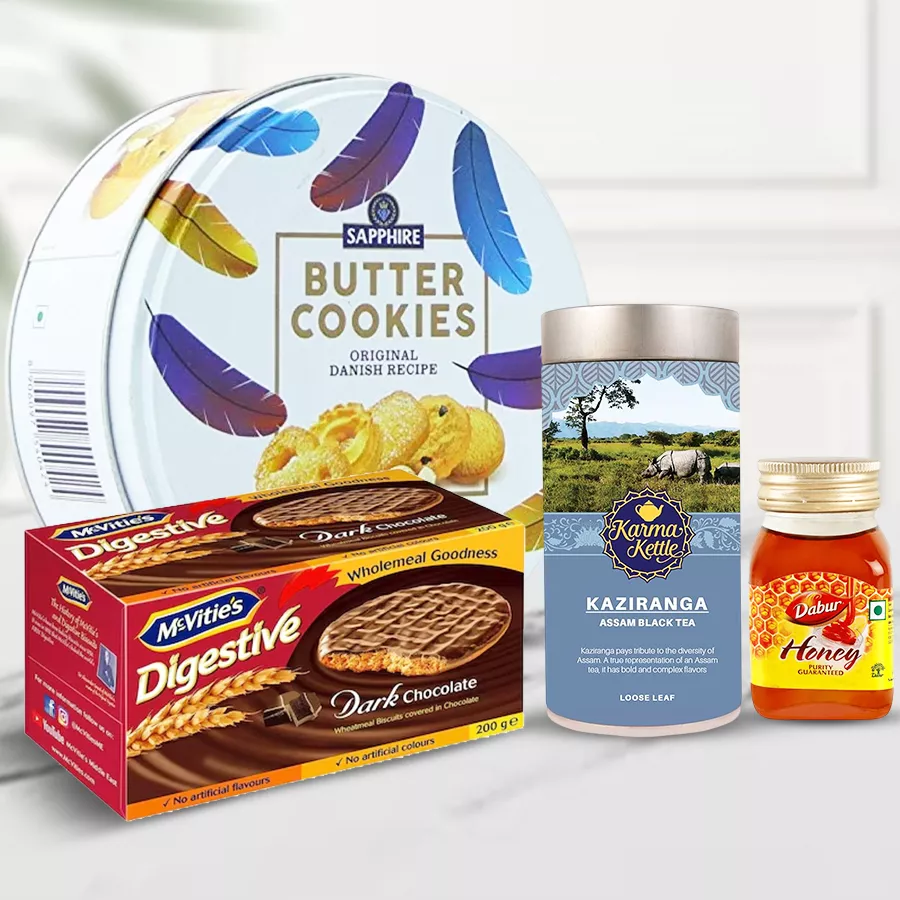 Finest Kaziranga Tea with Delights Gift Hamper featuring tea, cookies, biscuits, and honey.