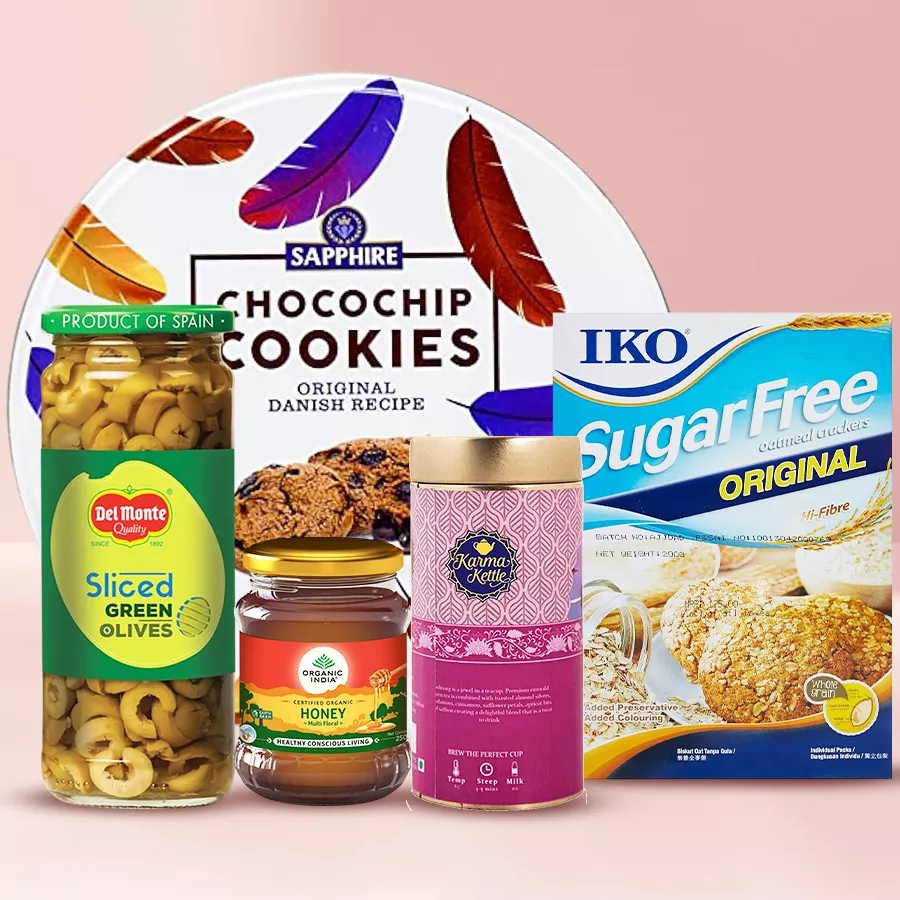Irresistible gift hamper featuring Karma Kettle Gulmarg tea, Sapphire cookies, sugar-free cookies, pure Indian organic honey, and Del Monte green olives.