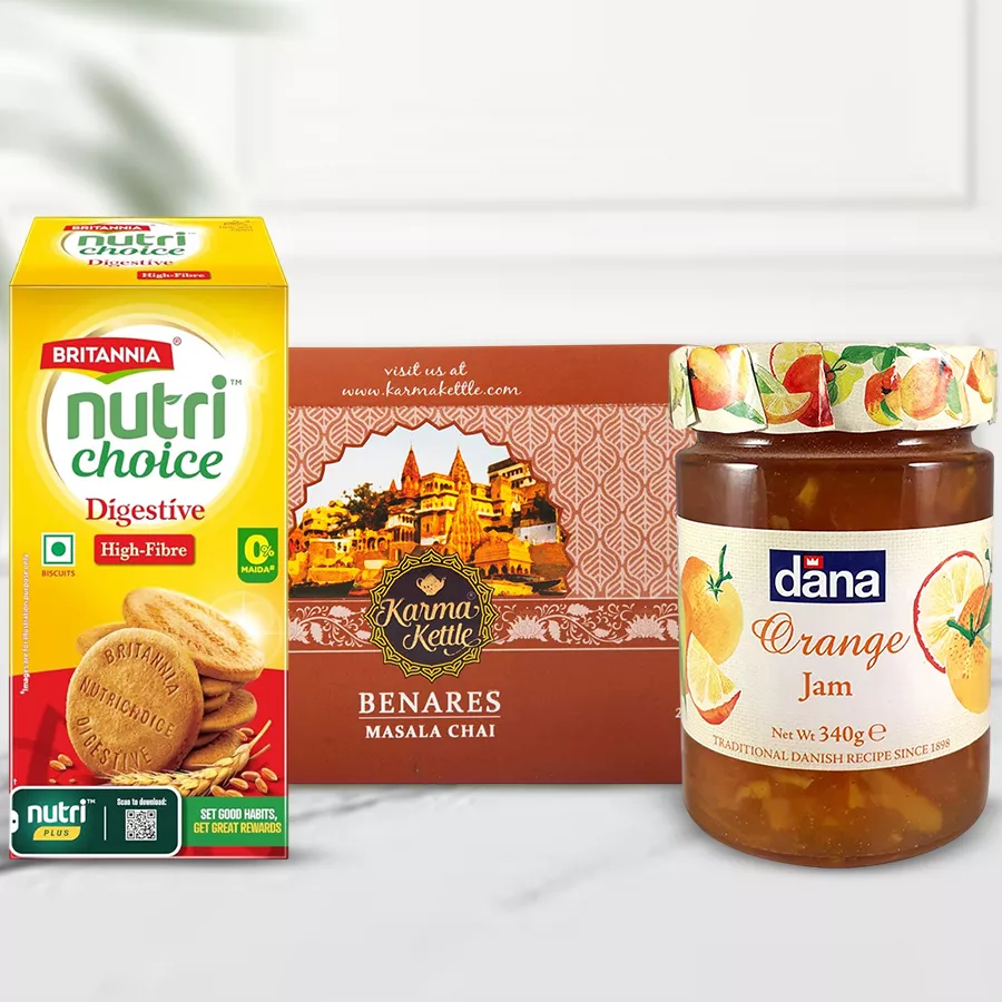 Cutting Masala Chai gift set featuring Karma Kettle Masala Chai, Britannia Nutri Choice biscuits, and Dana Jam arranged in a festive presentation.