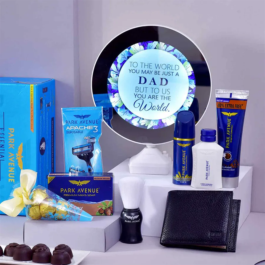 Hamper containing a magic mirror, leather wallet, handmade chocolates, and grooming kit for Father's Day gift.