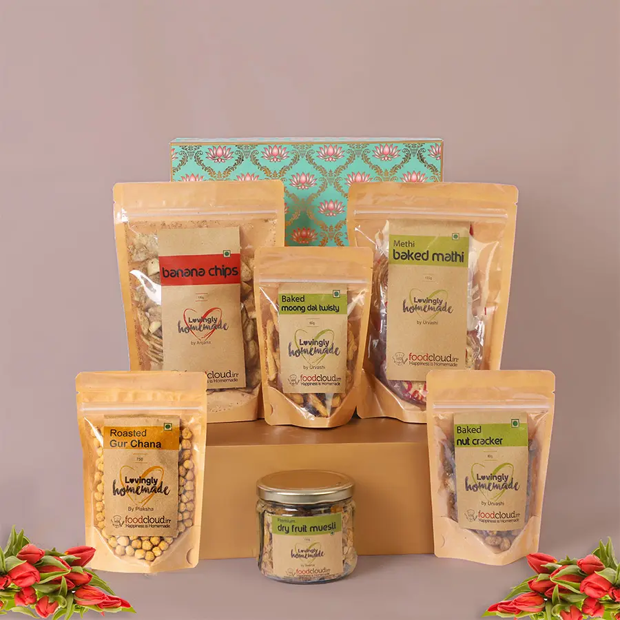 A beautifully arranged hamper of Wonder Maker Vegan Snacks Treat featuring banana chips, baked nut crackers, moong dal twisties, methi mathi, ragi bhujiya, and premium dry fruit muesli, perfect for celebrating Raksha Bandhan.