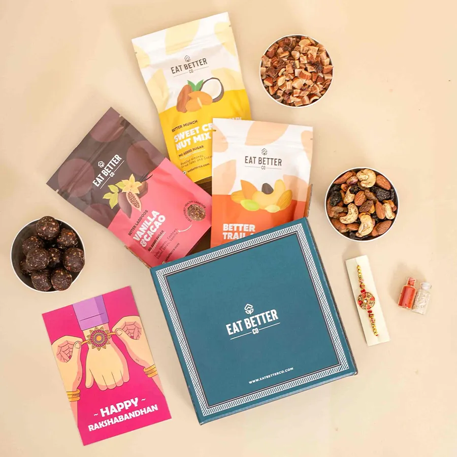 Unique Mandala Art gift box containing handcrafted rakhi, hazelnut chocolate laddoos, chocolate-coated almonds, cashews, and a crunchy nut mix, presented with Roli, Tilak, Chawal, and a greeting card.