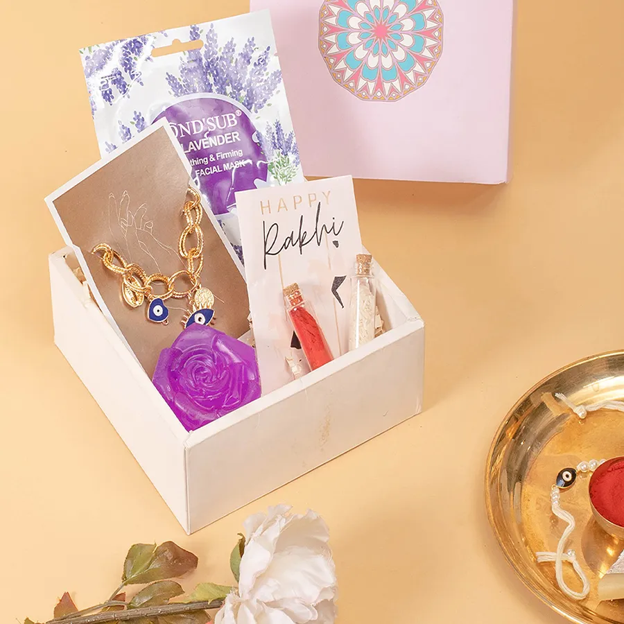 Alluring Rakhi Hamper featuring an Evil-Eye Charm Bracelet, Lavender Soap, MondSub Lavender Sheet Mask, Evil Eye Rakhi, and violet gift box