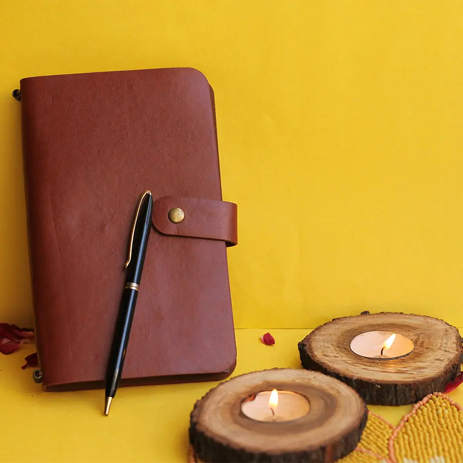 Journal N Candle Gift Set featuring a Leatherite Travel Journal, stylish pen, and handcrafted wooden log candles arranged on a table.