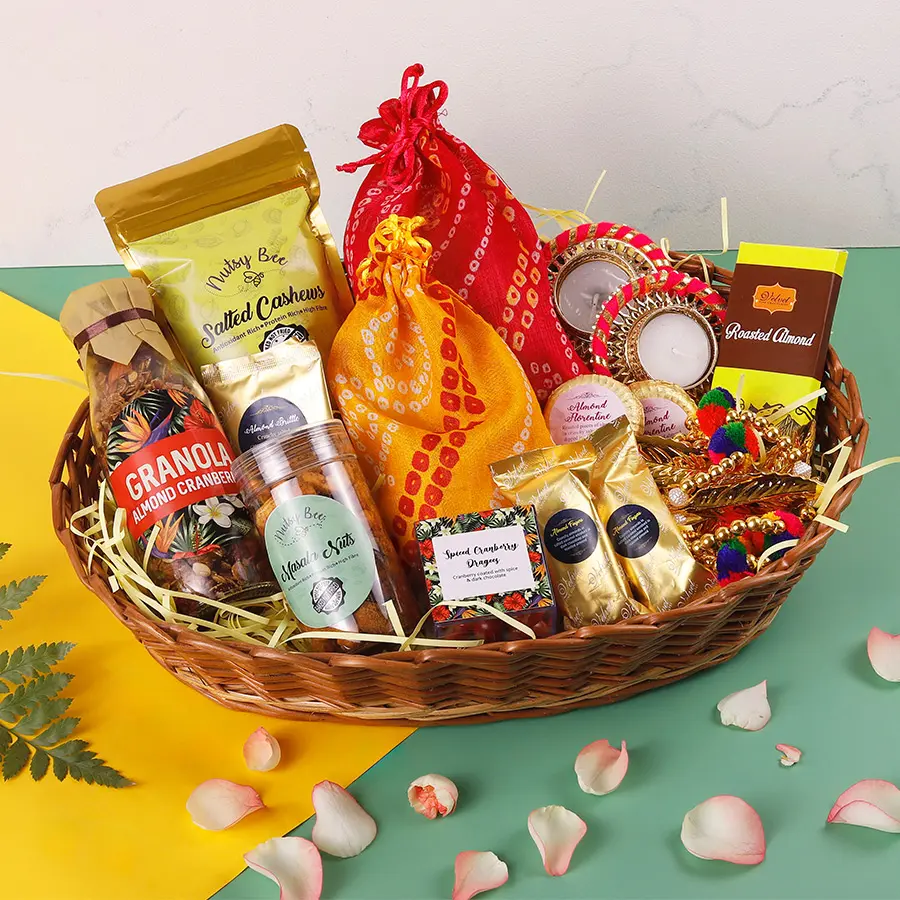 Luxury Delights Diwali Elegance Basket filled with gourmet treats including almond cranberry granola, salted cashews, chocolate bars, assorted chocolates, two diyas, and a vibrant toran