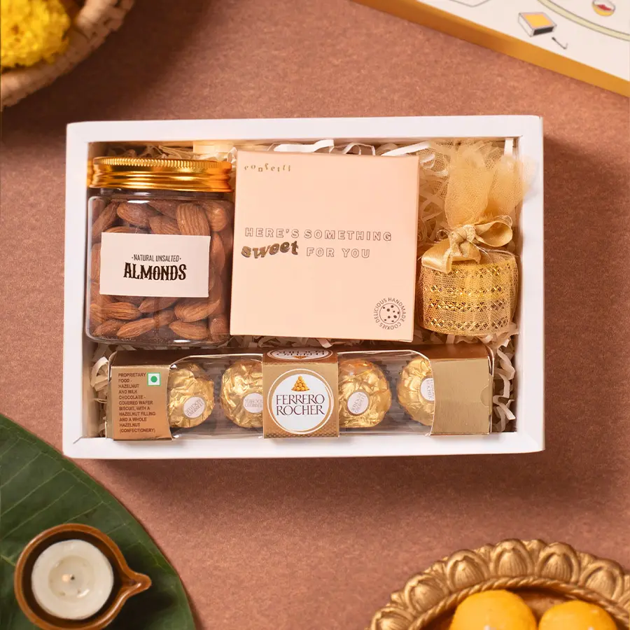Festive Treats And Glow Gift Box featuring T-light candles, Ferrero Rocher chocolates, handmade chocochip cookies, and premium almonds in a marigold slider box.
