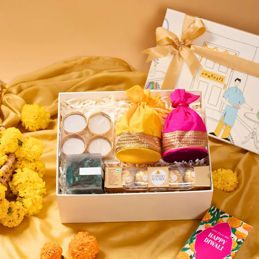 Gift box containing almonds, cashews, Ferrero Rocher chocolates, t-light candles, and green potpourri, all presented in a festive house-shaped box for Diwali celebrations.