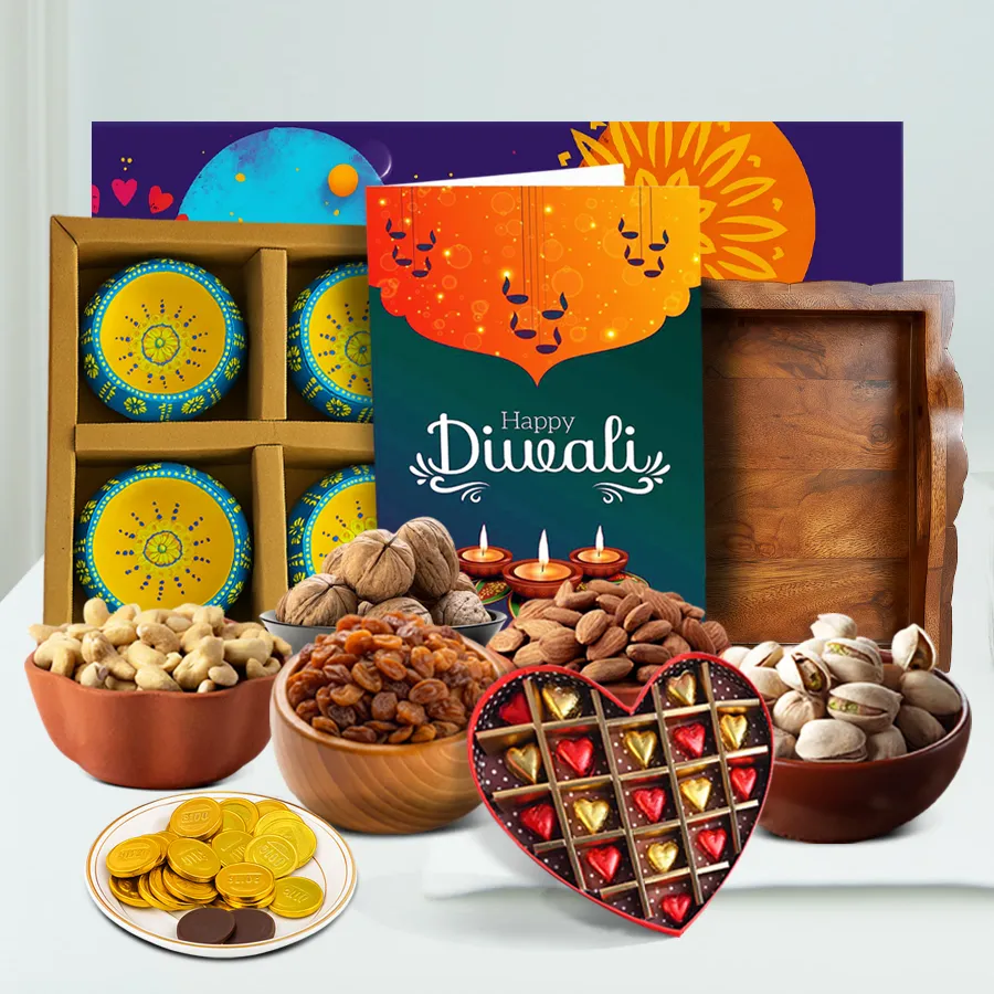 A beautifully arranged festive hamper filled with chocolates, nuts, designer clay diyas, and a Happy Diwali card on a fancy tray.
