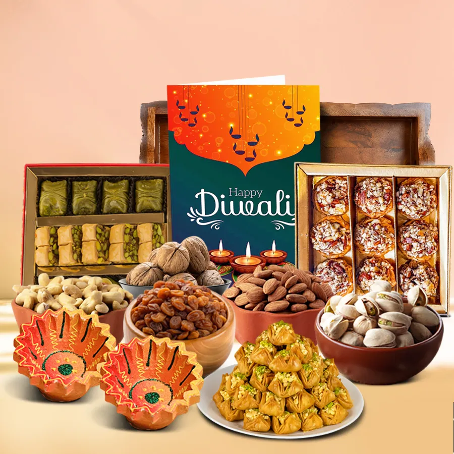 Sensational Diwali Treats N Nuts Hamper featuring cashew, almond, and pistachio baklawa, premium nuts, designer clay diyas, and a Happy Diwali card arranged on a fancy tray