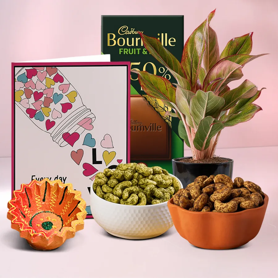 Diwali gift hamper featuring a traditional Diya, Aglaonema Lipstick Plant, Cadbury Bournville Fruit n Nut chocolate, and Pudina and Pepper Cashews, with a personalized message card.
