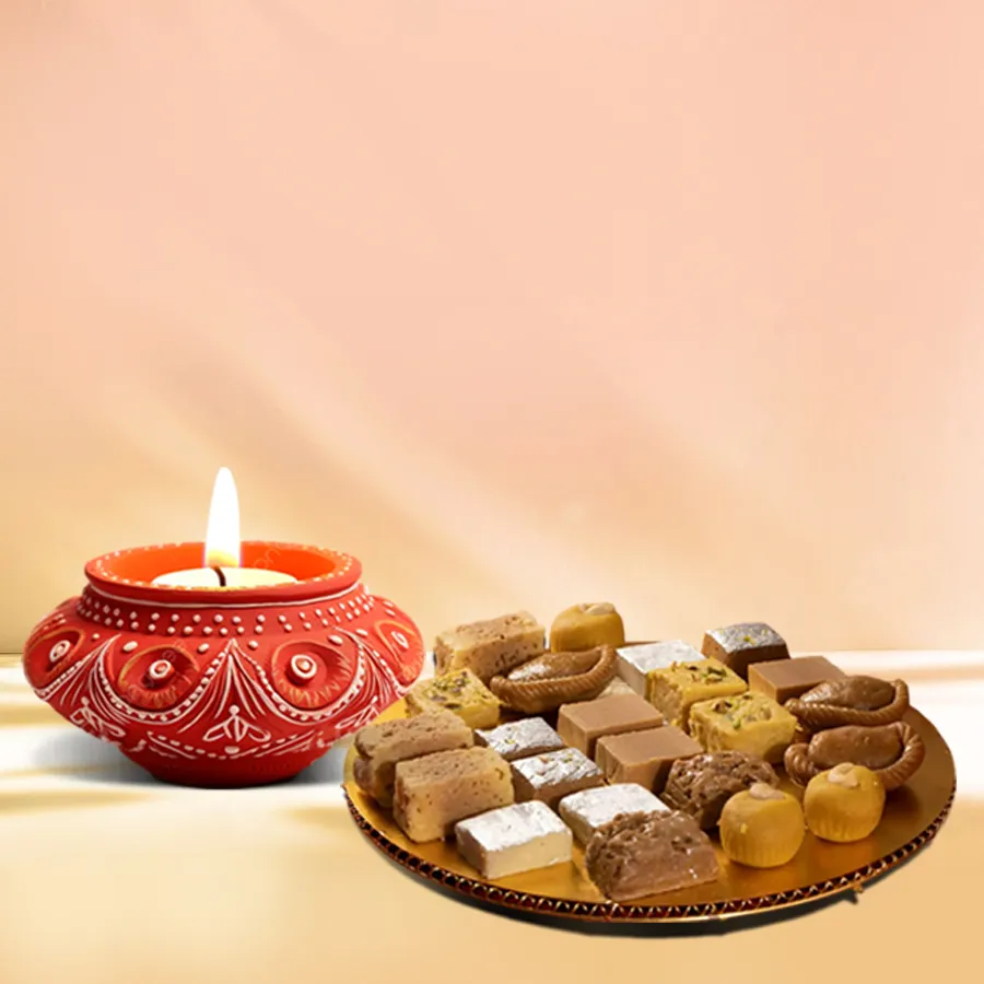 Sweet Celebrations Diya And Treats Hamper featuring a beautifully crafted diya and an assortment of sweets.