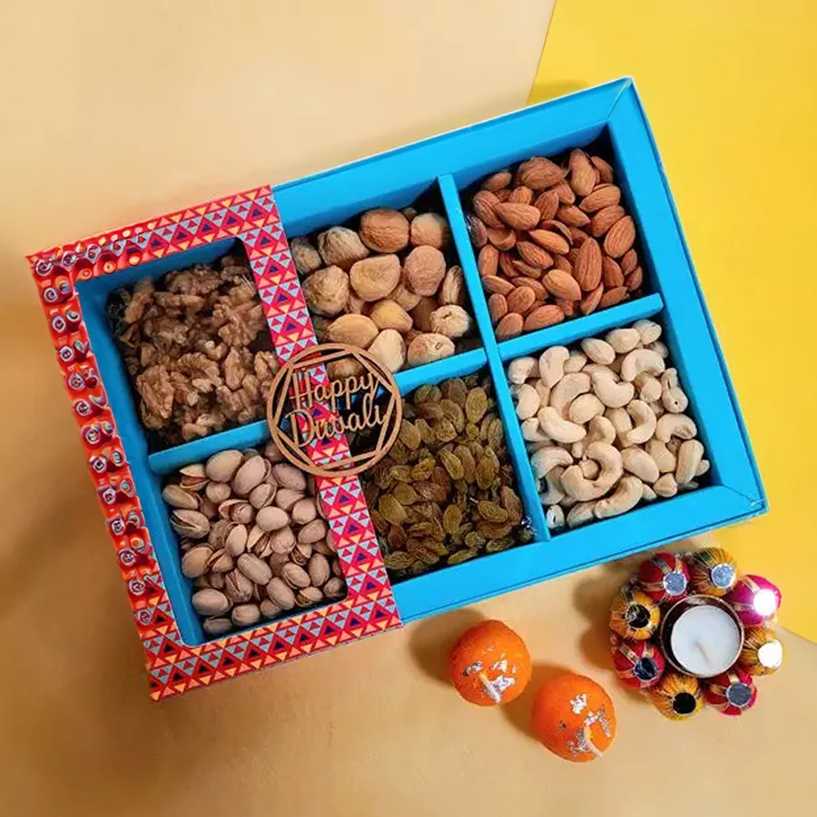 Diwali hamper featuring premium nuts, dried fruits, and decorative candles in a gift box.