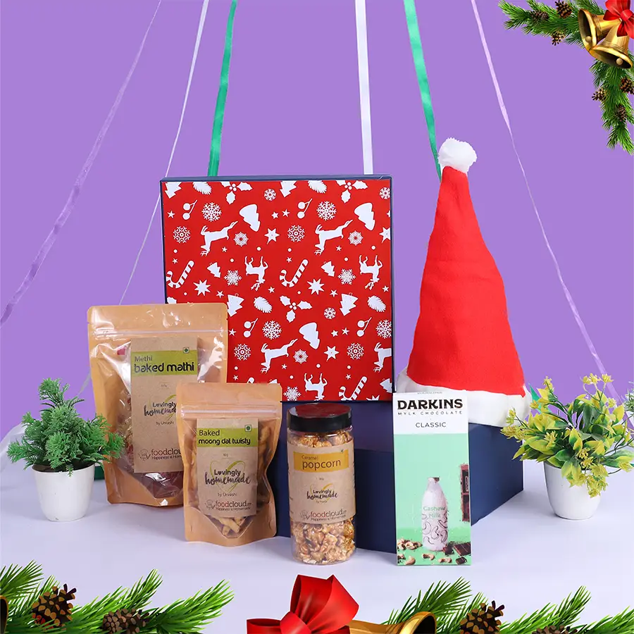 Ultimate Christmas Treats Gift Hamper featuring Classic Milk Chocolate, Baked Moong Dal Twisty, Caramel Popcorn, Baked Mathi, and a Santa Cap