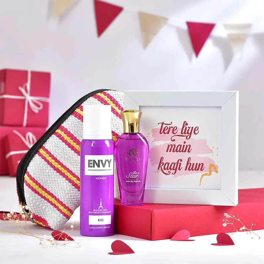 Unforgettable Moments Bundle Hamper featuring a white photo frame, Envy Kiss Perfume, Yardley London Be a Star fragrance, and a colorful washable pouch made from recycled plastic