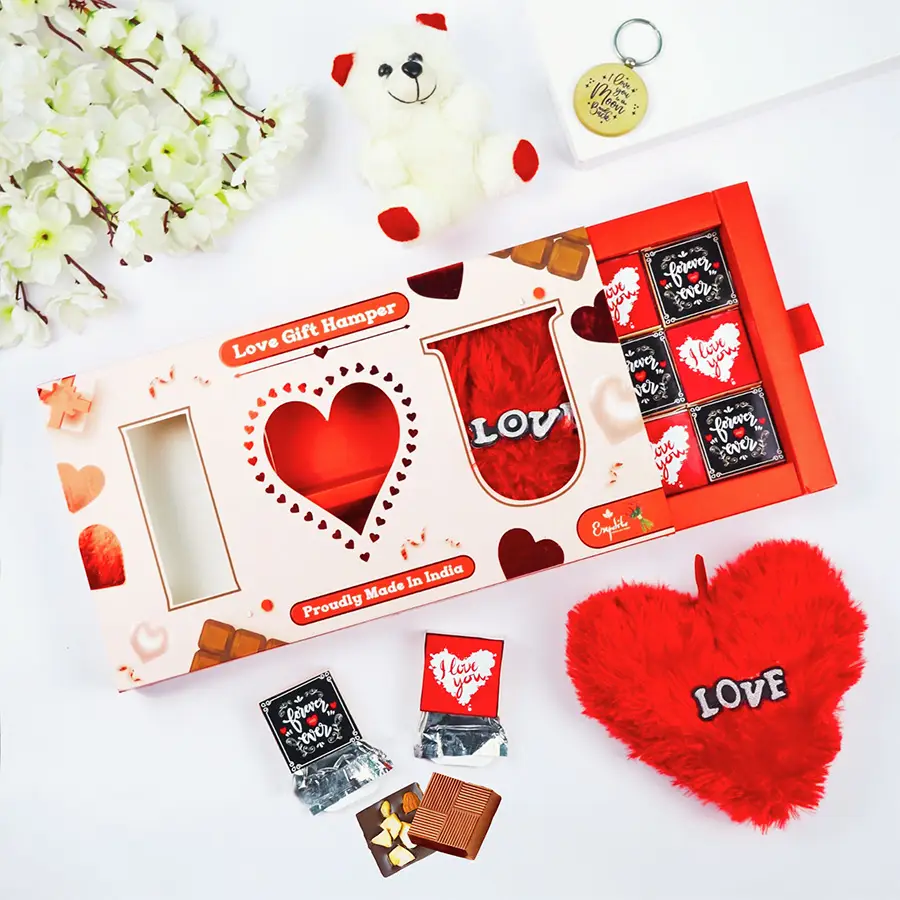 Valentine's Day gift box containing assorted chocolates, a teddy bear, a heart-shaped pillow, and a wooden keyring, elegantly presented in an "I Love You" shaped box.