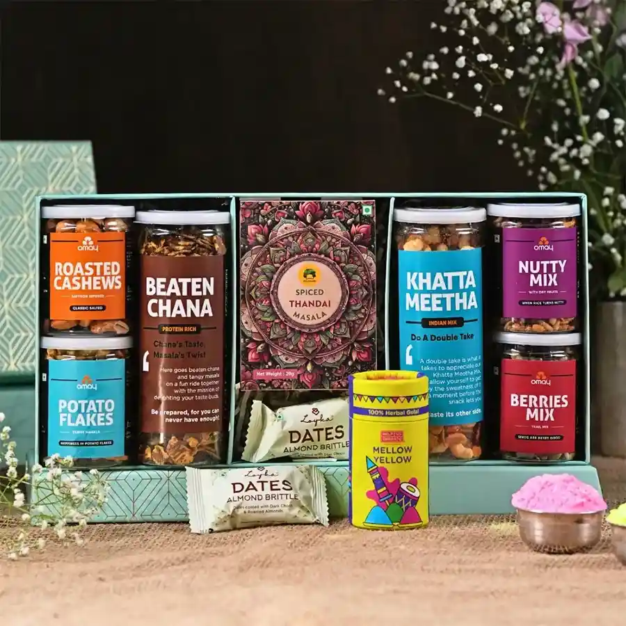 Toothsome Holi Delights Treat Box with assorted snacks, herbs, and a greeting card displayed in a gold-foiled box.