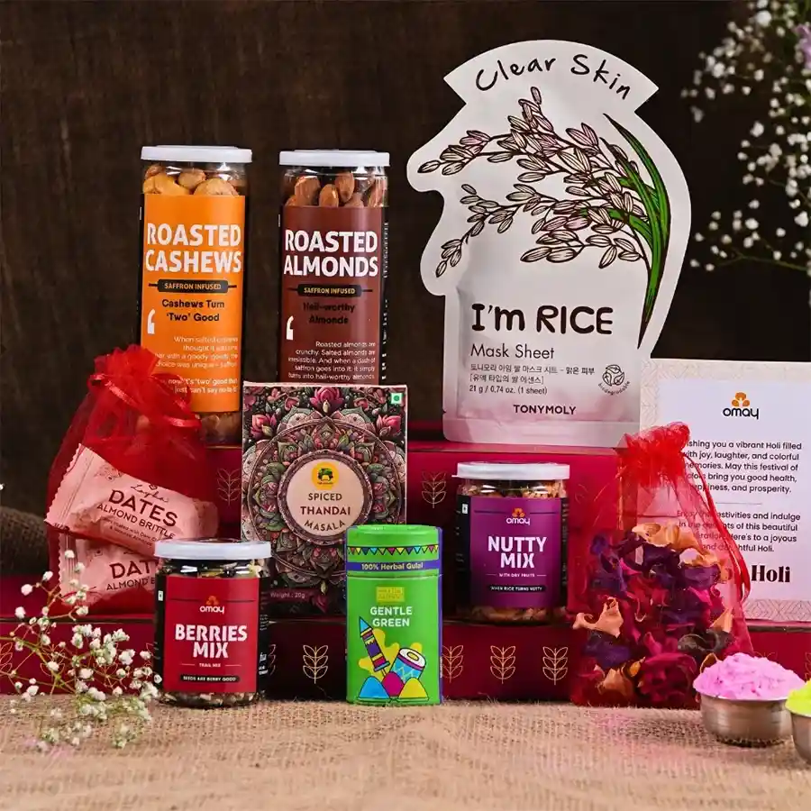 Luxe Holi Treats Gift Set featuring roasted cashews, almonds, berries mix, nutty blend with dry fruits, scented potpourri, Tony Mony face mask, almond dates, Gulab's instant Thandai, herbal gulaal, and a Holi greeting card packaged elegantly.