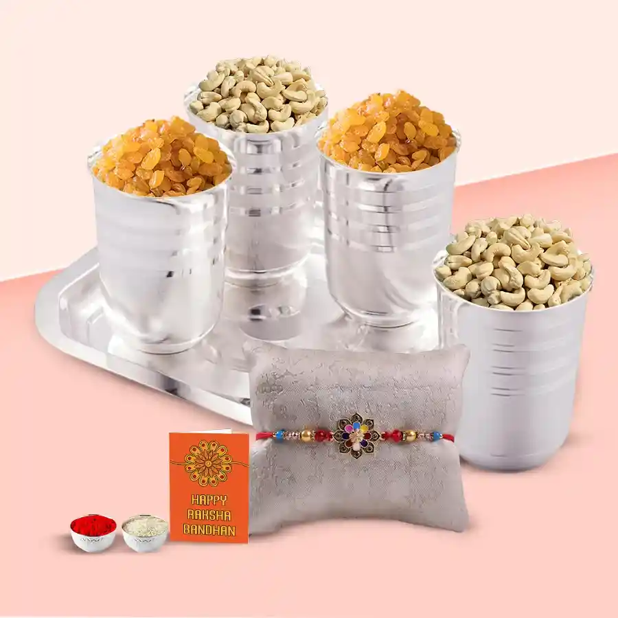 Luxury Dry Fruits Gift Set featuring four silver-plated glasses with cashews and raisins on a tray, accompanied by a Rakhi, Roli, Tilak, and Chawal.
