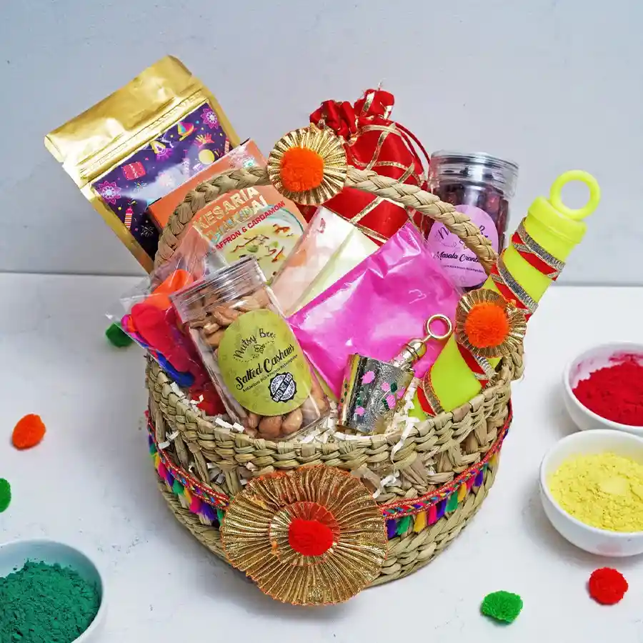 Joyful Festive Celebration Gift Hamper featuring treats like Kesaria Thandai, Chatpata Mix, Salted Cashews, Masala Cranberry, Strawberry Crisp Logs, Holi Balloons, Holi Colors, and a Laddu Gopal Balti Pichkari.