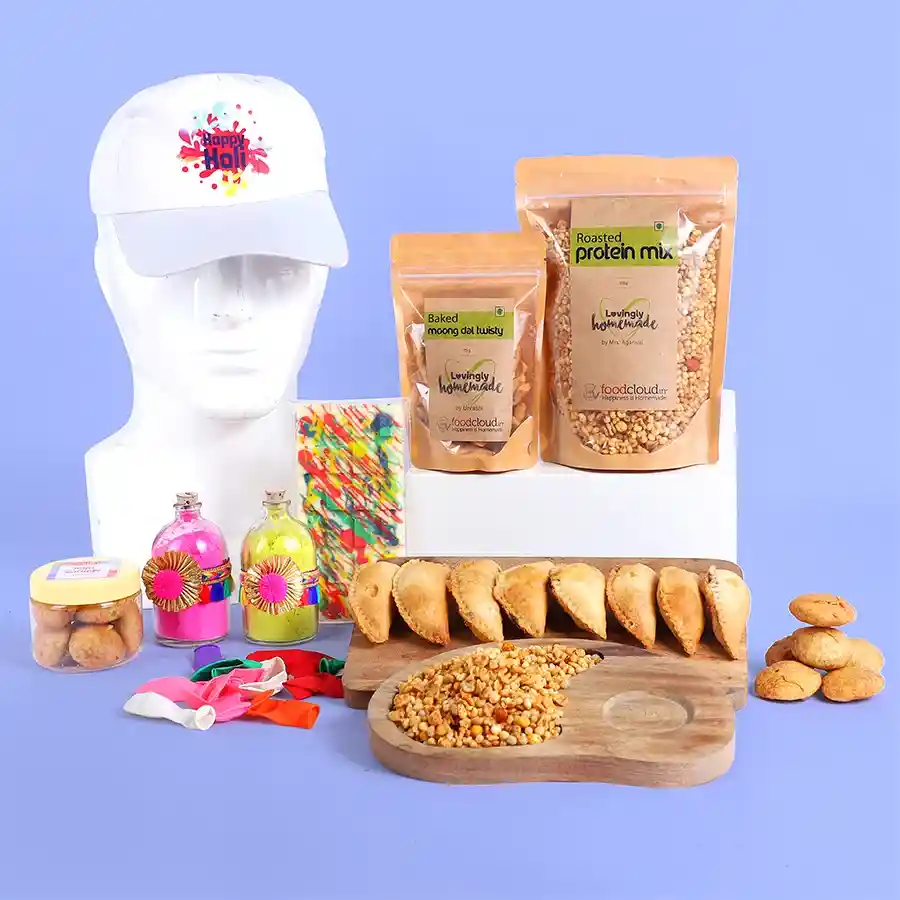 Radiant Holi Treats N Gifts Hamper featuring Baked Gujiya, Mini Kachori, Homemade White Chocolate, colorful balloons, organic Gulal jars, and a festive Holi cap.