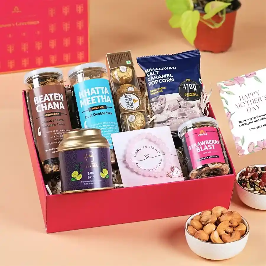 Luxurious Mother's Day Surprise Box with gold foil wrapping and assorted gifts including snacks, chocolates, a bracelet, tea, and a greeting card