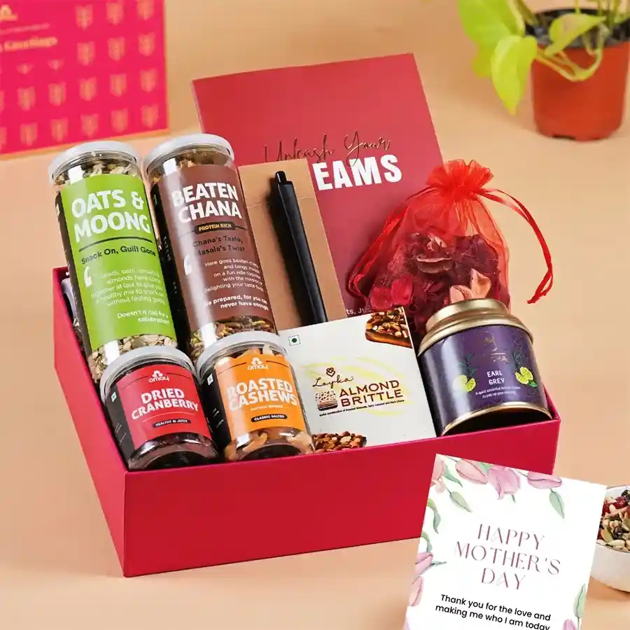 Luxe Mother’s Day gift box featuring gold packaging with Oats N Moong, Beaten Chana, Roasted Cashews, Dried Cranberries, Oh Cha! Herbal Tea, Loykas Chocolate Almond Brittle, scented potpourri, custom notepad with pen, and a heartfelt greeting card.