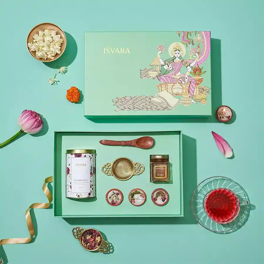 Tea Time Essentials Gift Set featuring organic hibiscus and lavender teas, brass tea strainer, Himalayan forest honey, floral petite candles, and Sheesham wood teaspoon in a decorative keepsake gift box.