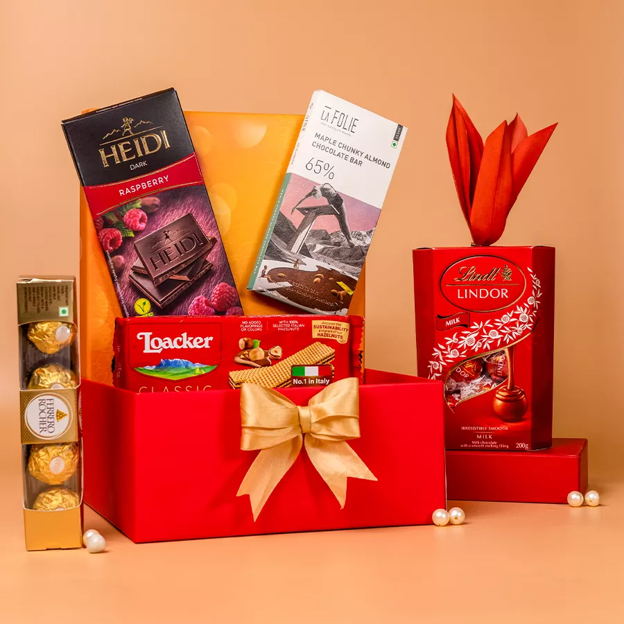 Divine Chocolate Delights Hamper featuring Lindt Lindor Milk Chocolate Bar, Loacker Classic Wafers, Hedi Dark Raspberry Chocolate, La Folie Maple Chunky Almond Bar, and Ferrero Rocher chocolates in a reusable gift box.