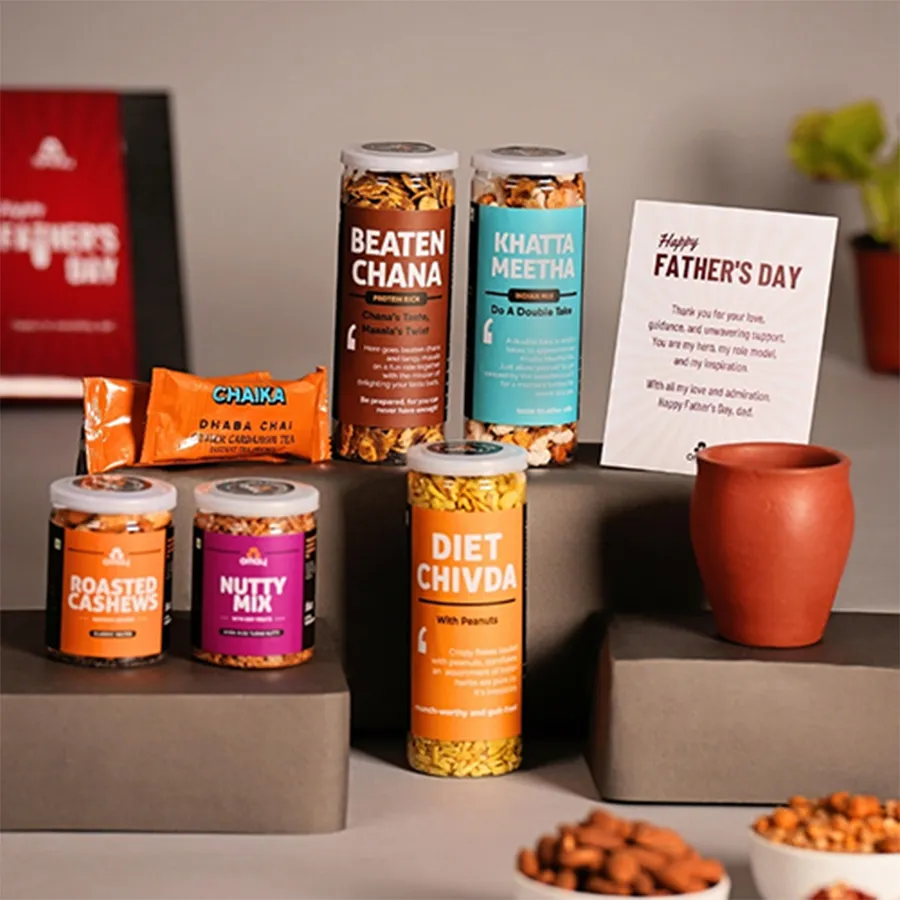 Father's Day treat hamper featuring Beaten Chana, Khatta Meetha, Diet Chivda, Saffron Roasted Cashews, Nutty Mix with dry fruits, a ceramic kulhad, and Chaika instant tea sachets, all presented with a greeting card.