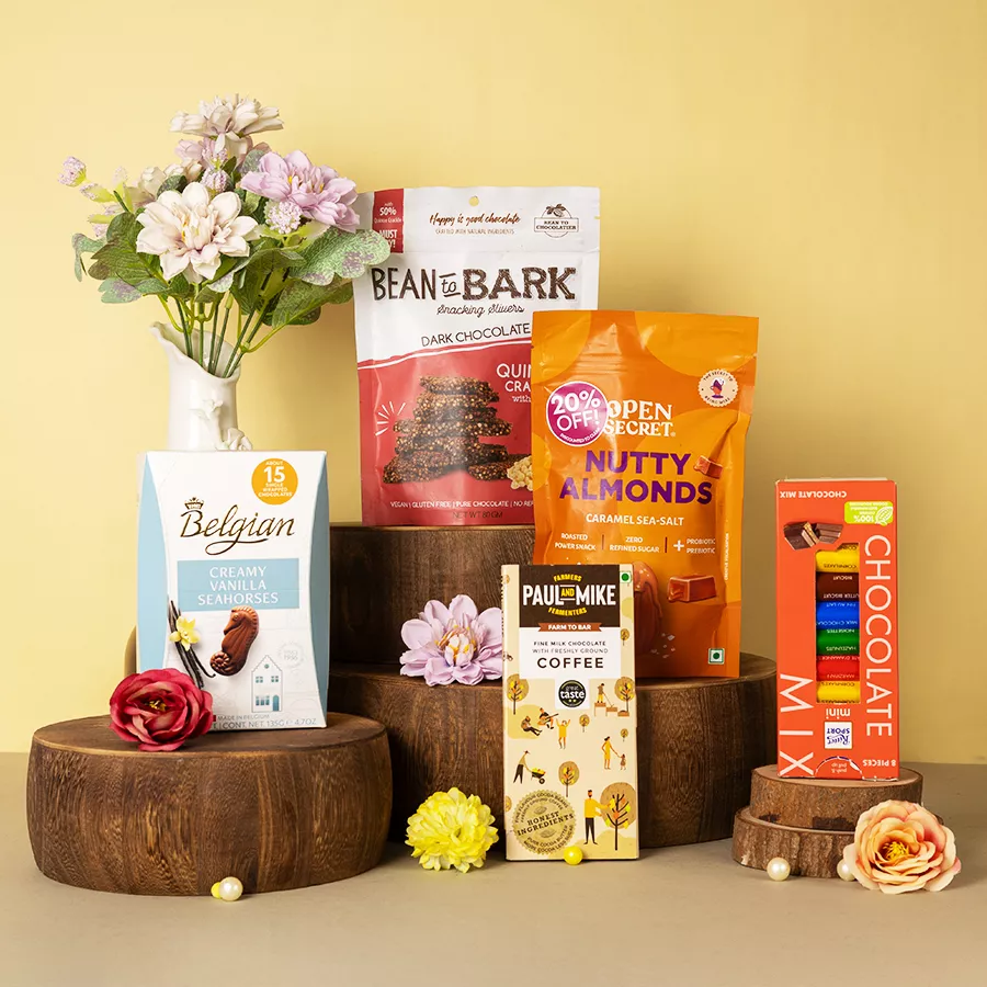 Exquisite Chocolates N Nut Treat Hamper featuring Belgian Creamy Vanilla Seahorses, Open Secret Almonds, Ritter Sport Minis, Dark Chocolate Quinoa Crackle, and a Paul Mike Coffee Bar.