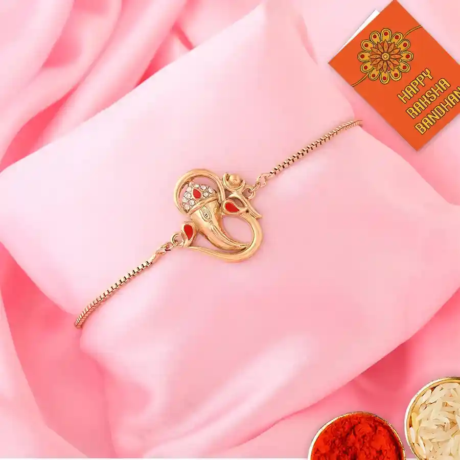 Elegant Gold Plated Rakhi set with intricate designs and accompanying Roli, Tilak, and Chawal packets.