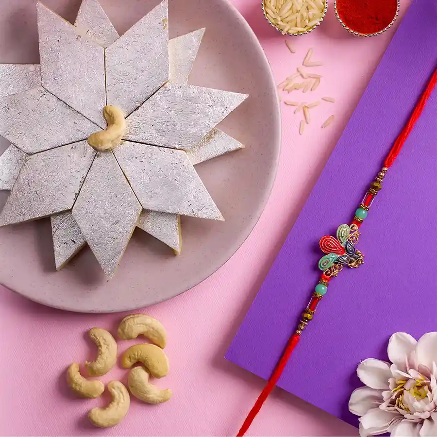 Kundan Rakhi with Kaju Katli box, Roli, Tika, Chawal, and a heartfelt message card for Raksha Bandhan celebration