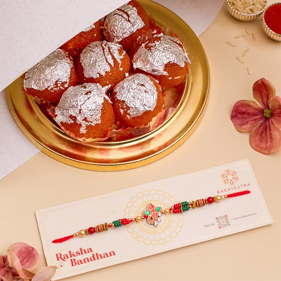 Ghee Laddu N Ganesha Rakhi Surprise bundle featuring Ganesha Rakhi, a box of 500g ghee laddus, and complimentary Roli, Tika, and Chawal with a message card.