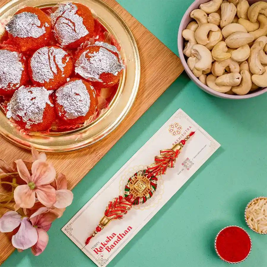 Elegant Kundan Rakhi gift pack with ghee laddus, cashews, roli tika, chawal, and a message card for Raksha Bandhan.