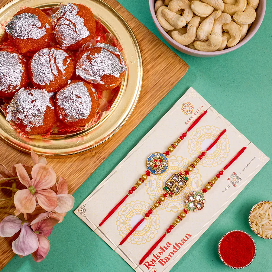 Premium Rakhi N Treats Combo featuring 3 Kundan Rakhis, 500g Ghee Laddu, 100g cashews, Roli, Tika, Chawal, a free message card, and an extra Rakhi.