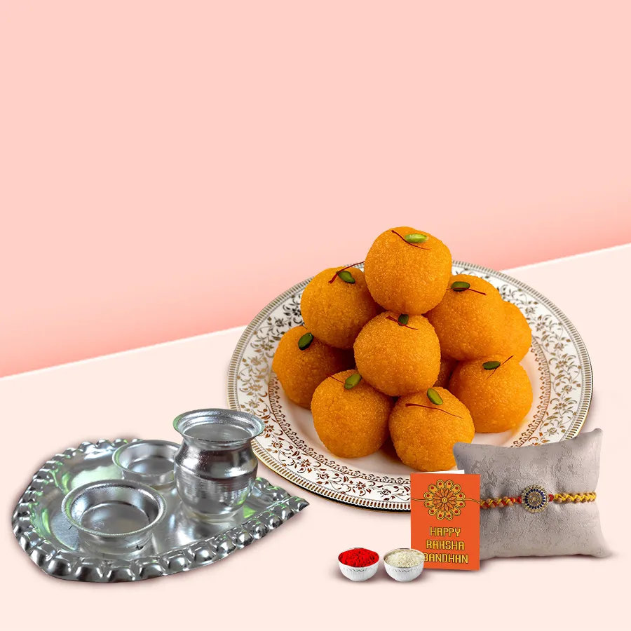 Laddoo from Haldiram, silver-plated paan-shaped puja aarti thali, roli, tilak, and chawal for Rakhi celebrations