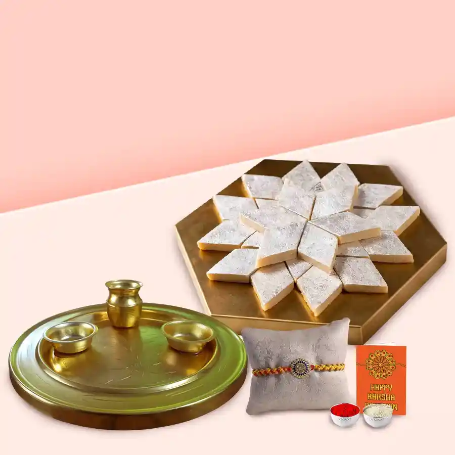 Gift set for Raksha Bandhan featuring Haldiram Kaju Katli, an embellished Rakhi, a gold-plated puja thali, and complimentary Roli Tilak and Chawal.
