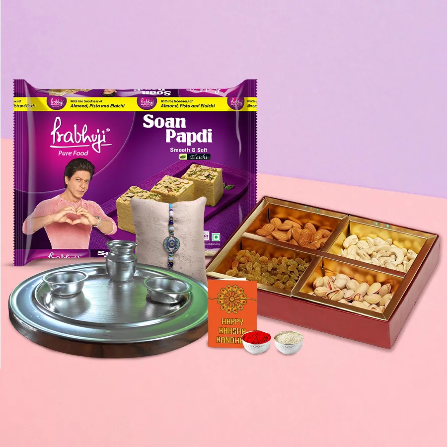 Graceful Rakhi Thali with Rakhi, Roli, Tilak, Chawal, Soan Papdi, mixed dry fruits, and an elegant silver-plated thali