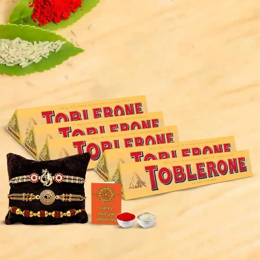 Delicious Toblerone chocolates with assorted flavors, a set of traditional Rakhis, and complimentary Roli, Tika, and Chawal for Raksha Bandhan celebration.