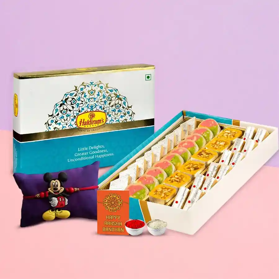 Assorted sweets from Haldiram with a colorful Kids Rakhi, Roli, Tilak, and Chawal set, ideal for Raksha Bandhan celebrations.