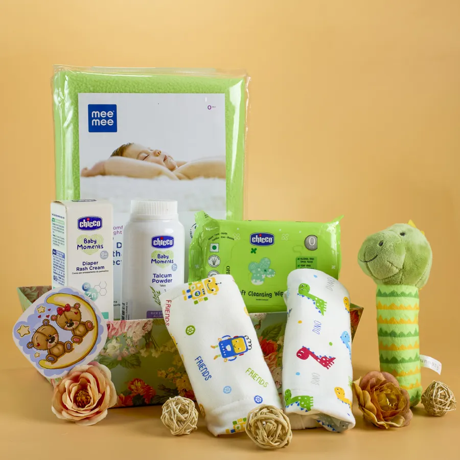 Baby Care N Comfort Essentials Gift Set arranged in a stylish reusable designer basket, featuring Mee Mee Dry Sheets, two Cotton Nappies, Chicco Talcum Powder, Diaper Rash Cream, soft wipes travel pack, and an adorable Plush Rattle.