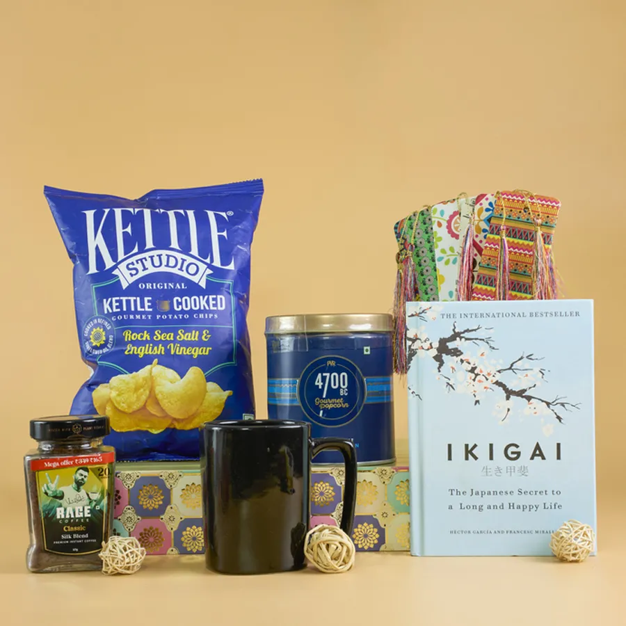 Cozy Reading and Gourmet Treats Gift Set featuring popcorn, potato chips, coffee mug, book, and a designer basket.